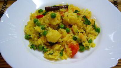 пряный рис с цветной капустой, зеленым горошком и помидорами